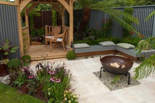 gazebo, patio, fire pit & flowers in tropical style show garden at RHS Show Tatton Park