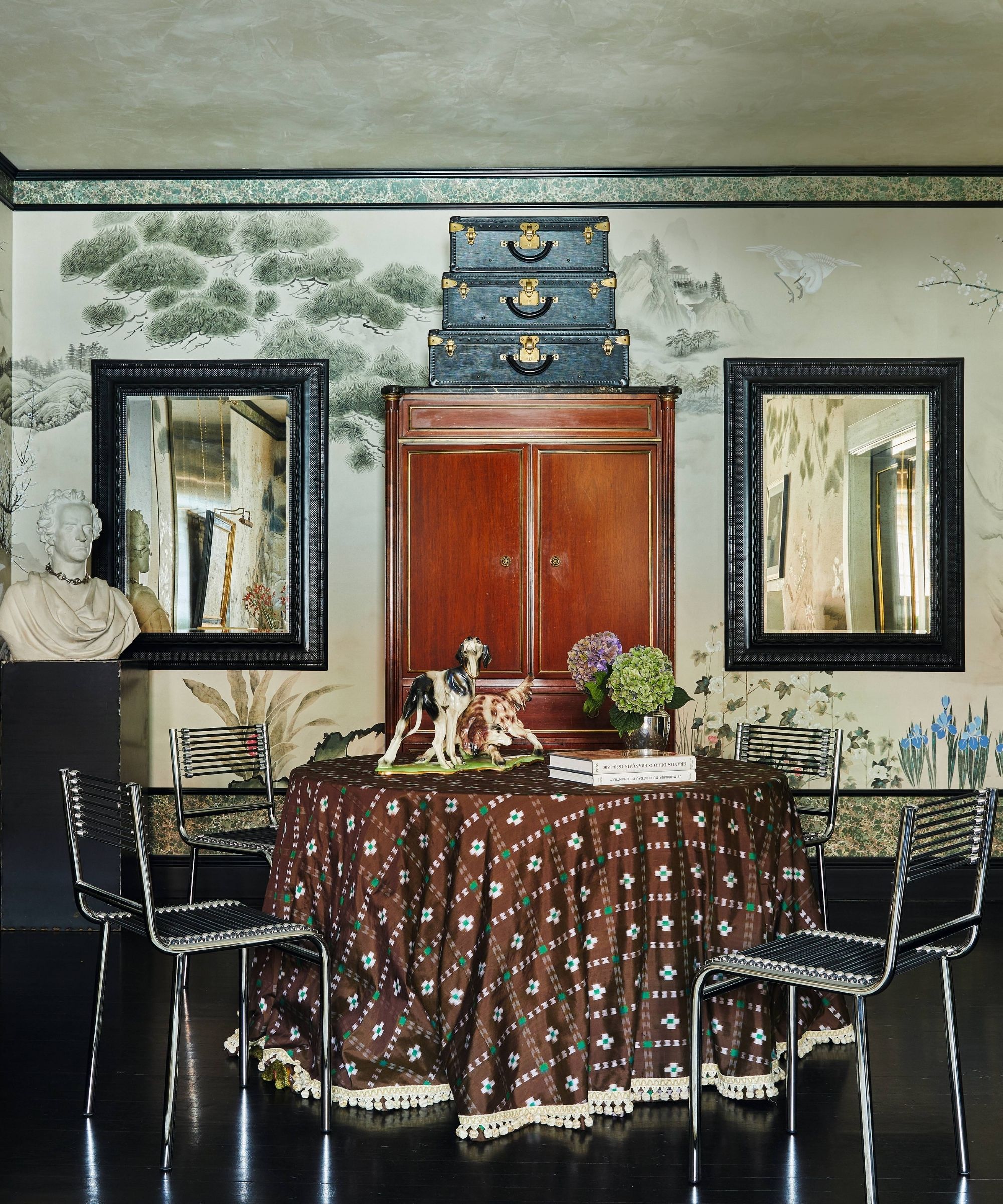 a large open living dining room in a new york apartment with mural wallpaper, vintage decor, round table and chairs with dark floors