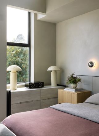 A guest bedroom with a side table and credenza