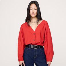 model wears red top and dark wash blue jeans with boots, second model wears whit sweater and white/khaki pants with boat shoes and a beanie, and the third is wearing a blue ruched top and white pants