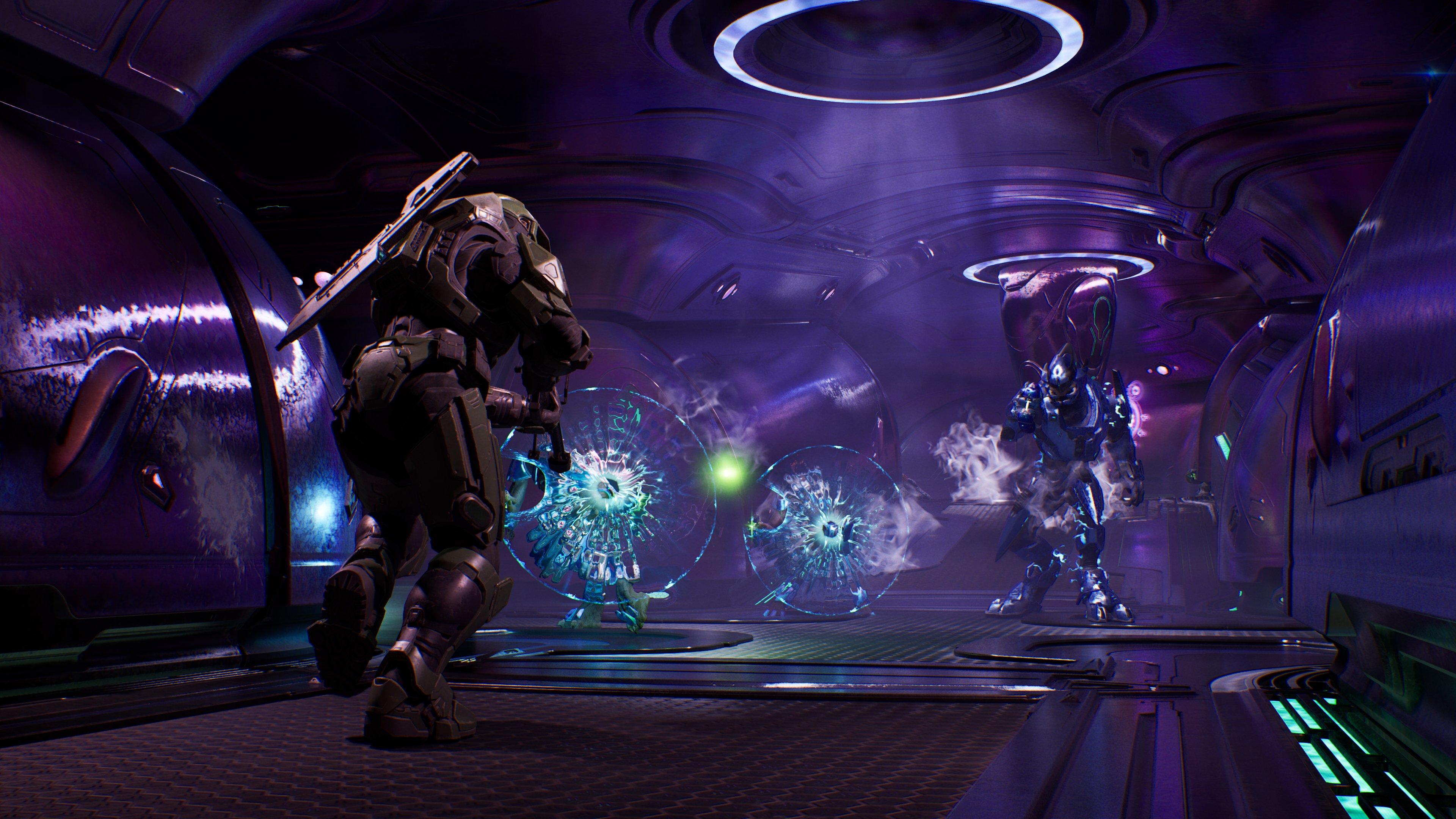 Master Chief confronts Covenant forces inside a purple-lit alien ship corridor, with energy shields and plasma fire illuminating the scene.