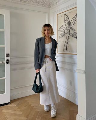 woman wearing white sneakers with spring skirt and blazer outfit