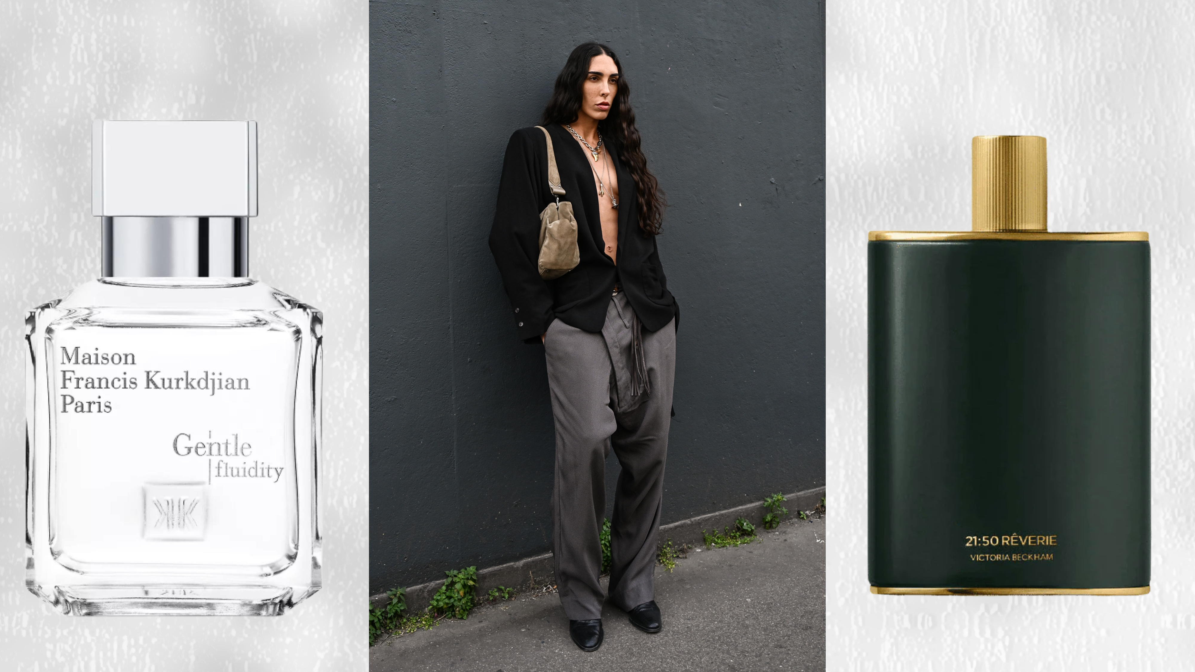 A woman wearing a black button up with a deep v neck and gray jeans leaning against a black wall. She is next to two bottles of unisex perfume.