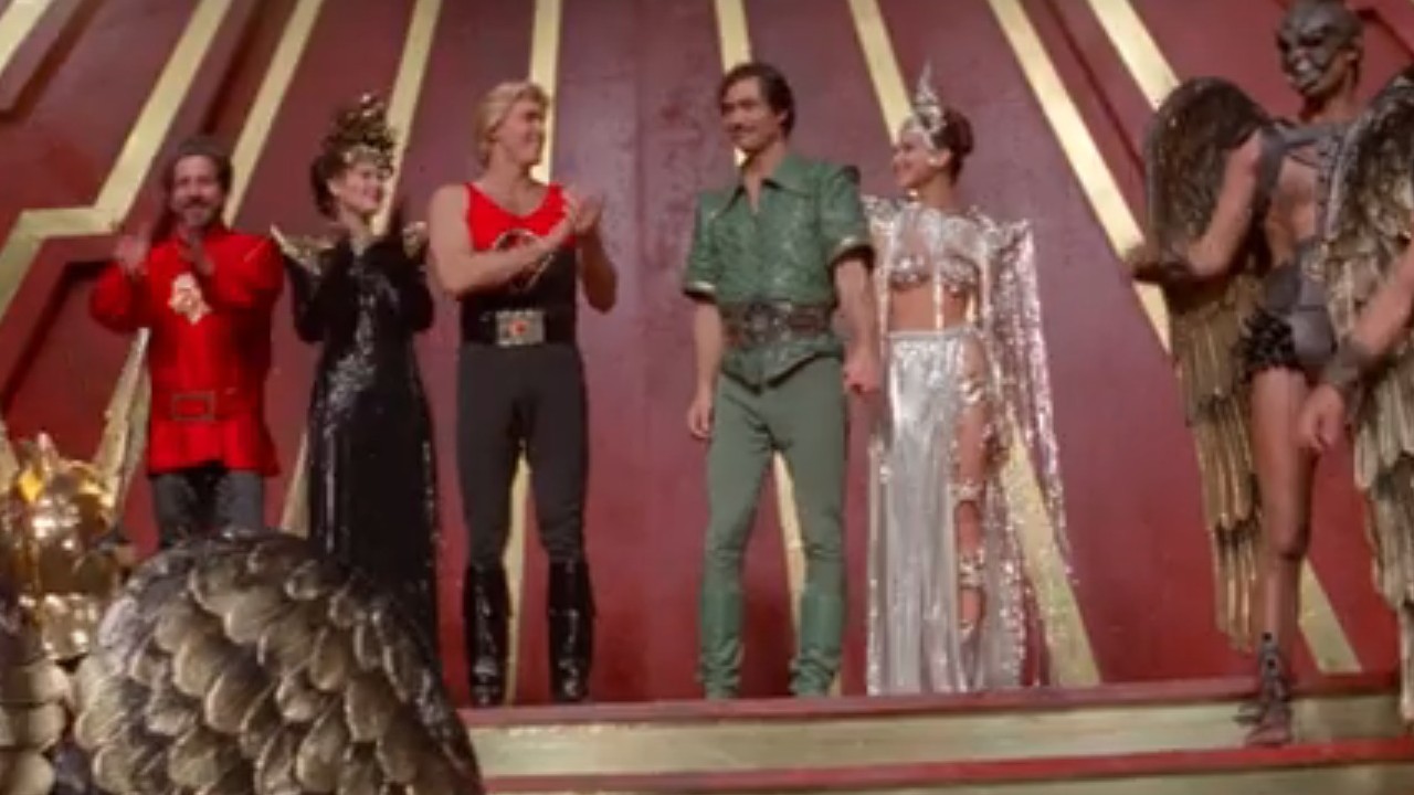 Sam J. Jones applauding Timothy Dalton in Flash Gordon