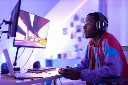 A young male gamer at his desk
