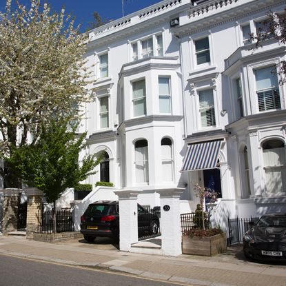 white multistoried building with white windows and green trees