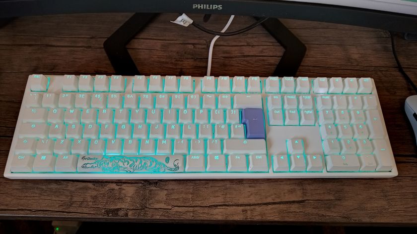 A white Ducky One 3 mechanical keyboard on a wooden desk.