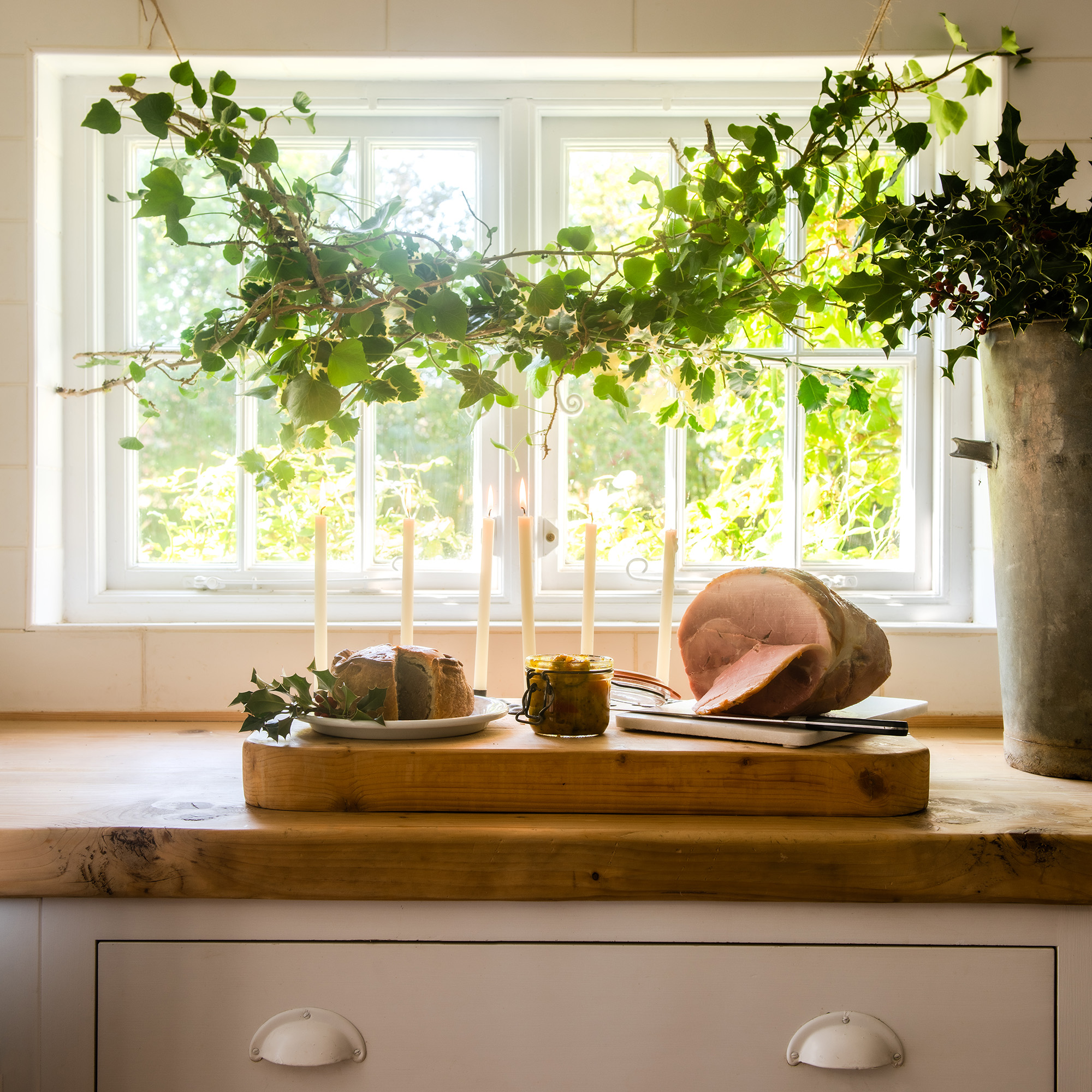 neutral kitchen with cream cabinets and wooden worktops dressed for christmas with mistletoe and festive foliage 1