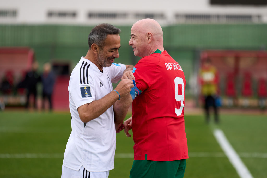 RABAT, MOROCCO - FEBRUARY 10: FIFA President Gianni Infantino (R) has his Captain&amp;amp;apos;s armbad adjusted by Chief Executive Officer of the FIFA Foundation Youri Djorkaeff (L) during a Legends match between the Rest of the World and Morocco at Stade Moulay Abdellah on February 10, 2023 in Rabat, Morocco. (Photo by Angel Martinez - FIFA/FIFA via Getty Images)