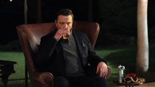 Peter Serafinowicz sitting in chair drinking in Million Dollar Secret.