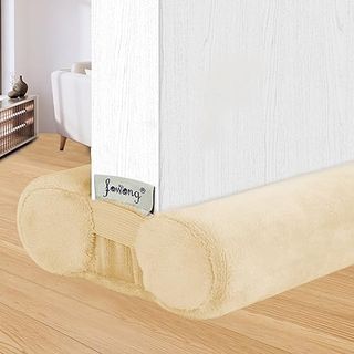 Dual draft stopper in fuzzy beige material shows the draft stopped placed underneath an open internal door and block drafts on both sides