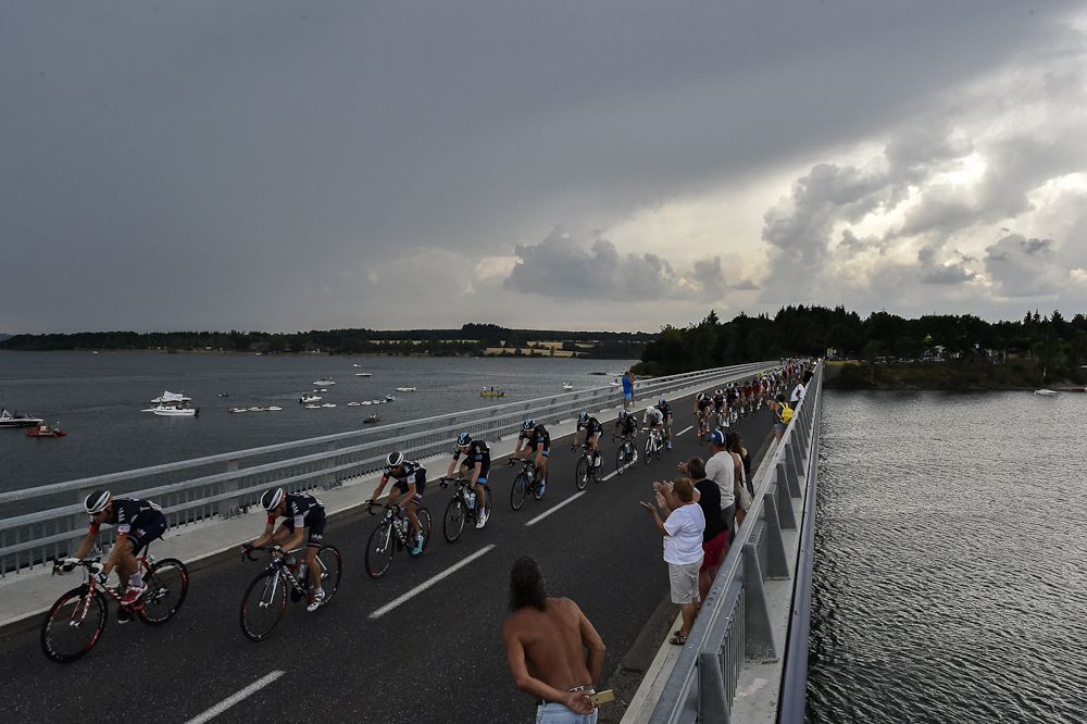 The peloton crosses a bridge during stage 14.