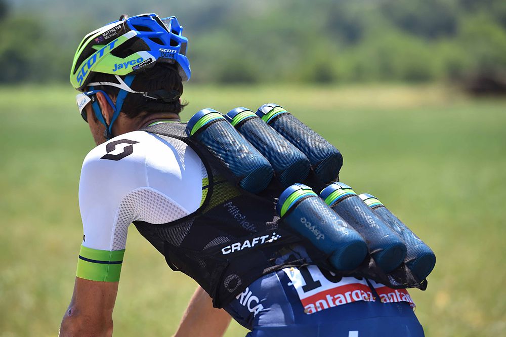 Orica-GreenEdge rider carries water bottles back up to the team