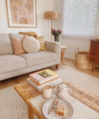 A beige and white living room with a couch and a coffee table with decor on it