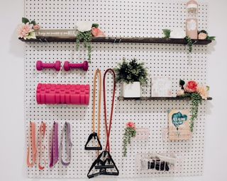 Gym storage idea peg wall with signage and plants
