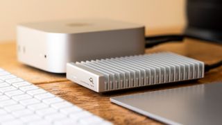 OWC Express 1M2 SSD enclosure on a table beside Apple Mac mini M4 and Apple Magic Keyboard