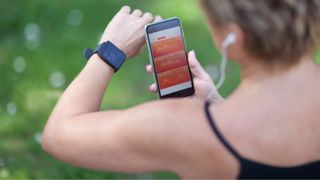 Woman wearing running watch, looking at fitness app