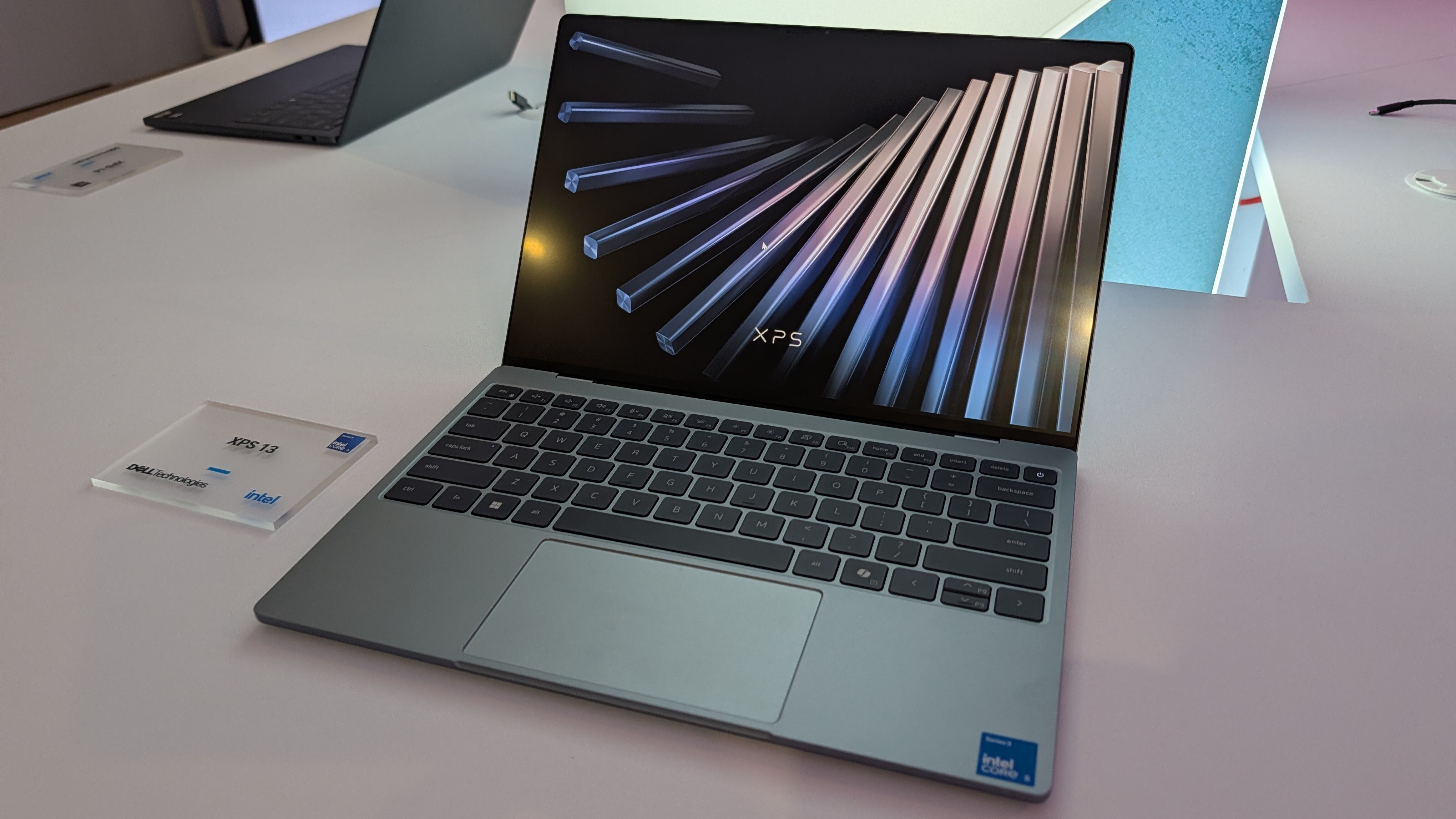 Dell XPS 13 laptop on display with an open screen showing colorful rods and "XPS" text.