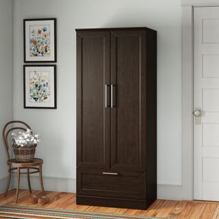 A tall, dark brown freestanding closet for coats