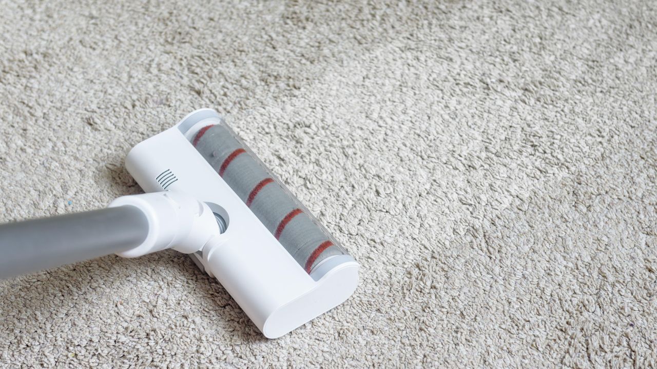 Cordless vacuum cleaner floorhead on gray carpet