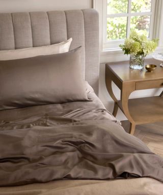 Cozy Earth Bamboo Sheet Set on a bed beside a nightstand.