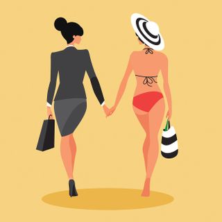 Two women walking hand-in-hand, one dressed in a suit the other in a bikini