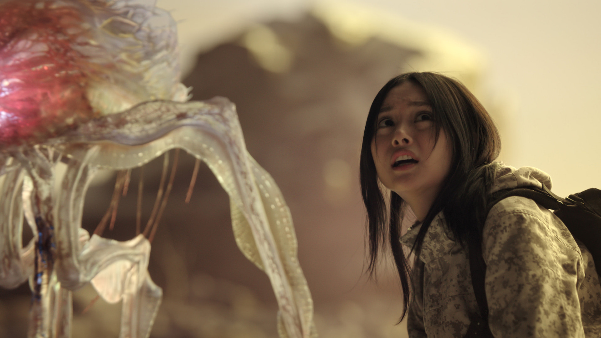 A translucent alien beside a frightened woman