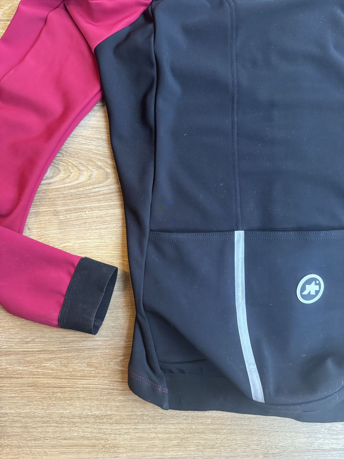 Flat lay of jacket from the back showing deep pockets and black ended cuffs
