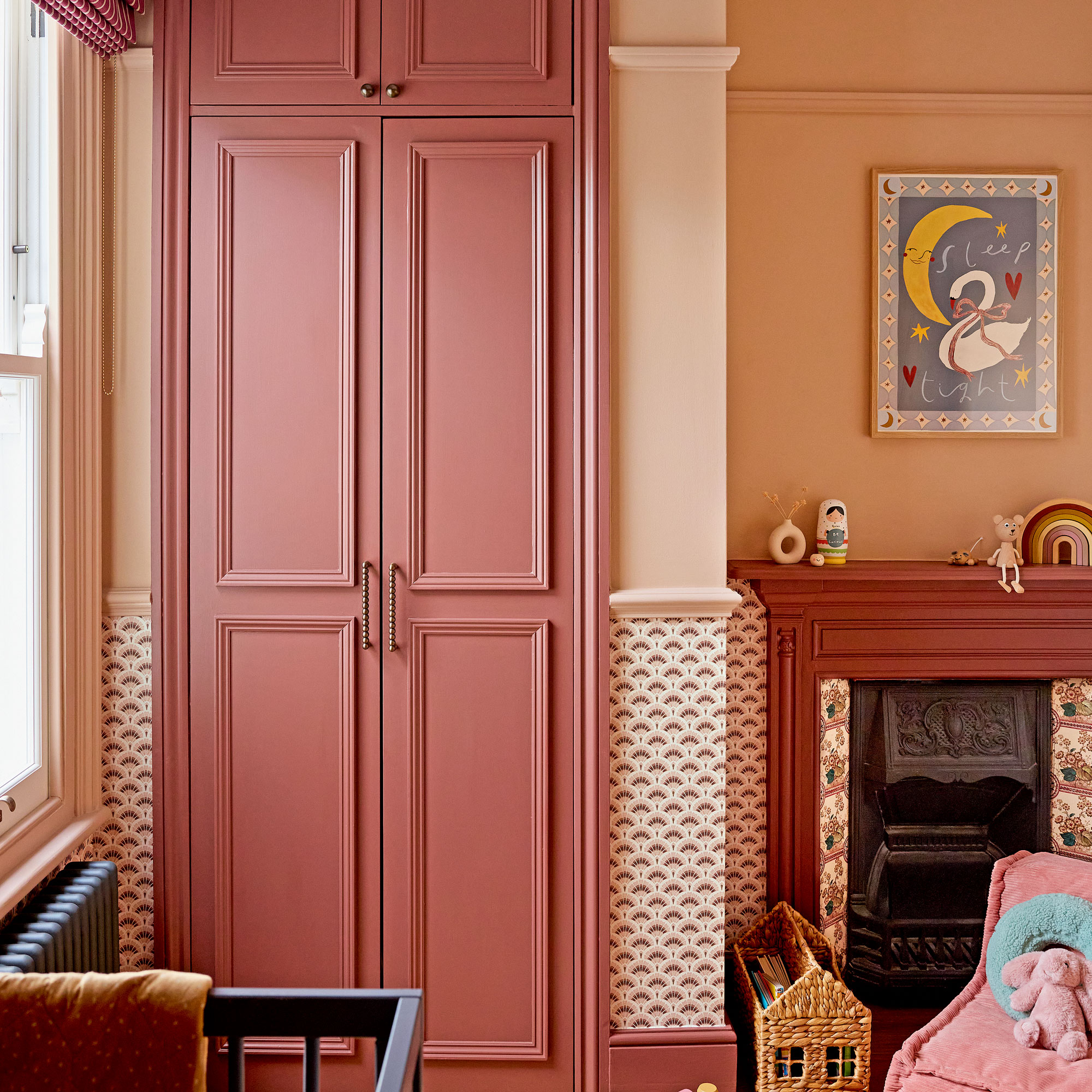 Pink walls and red cupboard and fireplace
