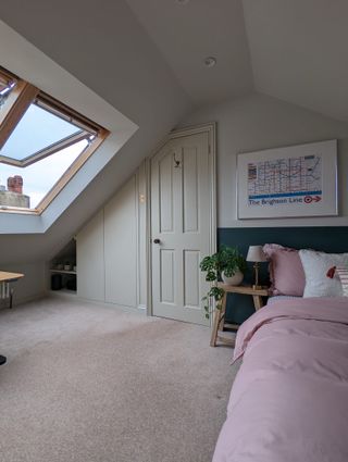 An attic bedroom with a skylight and an built in wardrobe in an alcove