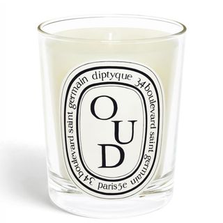 Diptyque's Oud candle in a class jar with a white label on a white background