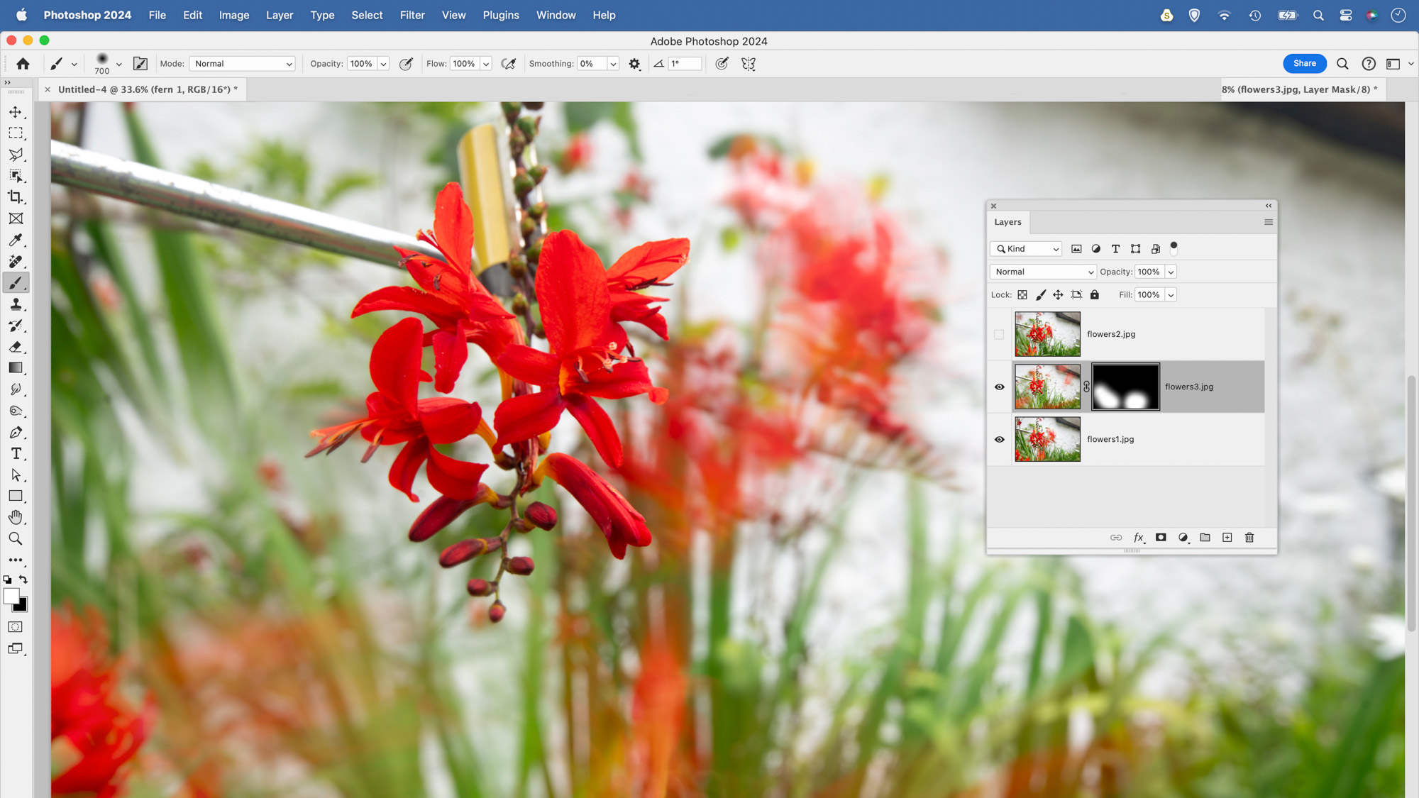 In this Photoshop CC screenshot the user has used a layer mask to hide parts of one flower image to combine it with another flower picture on the layer below