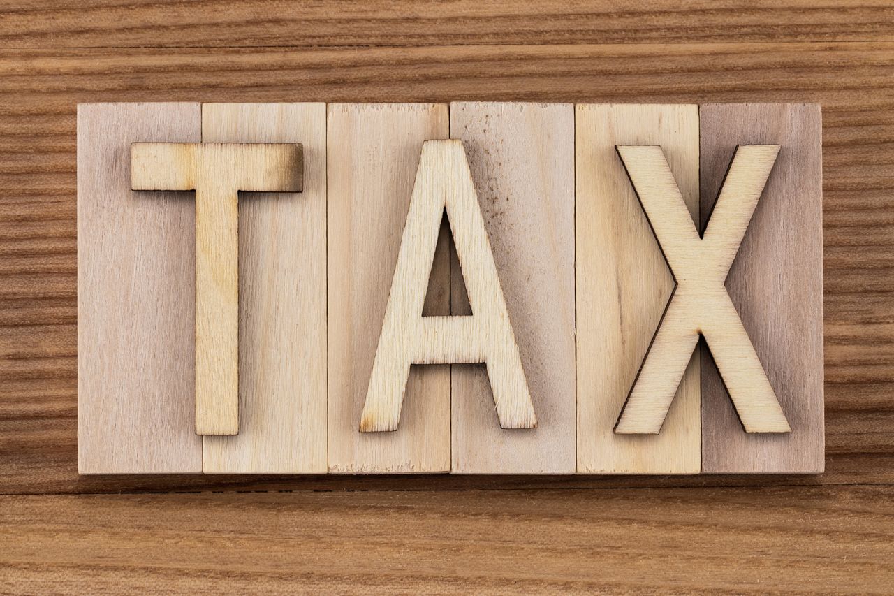 the word tax carved into wood