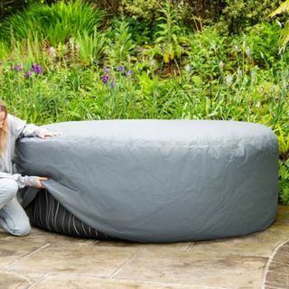 woman putting on Lay-Z Spa hot tub cover