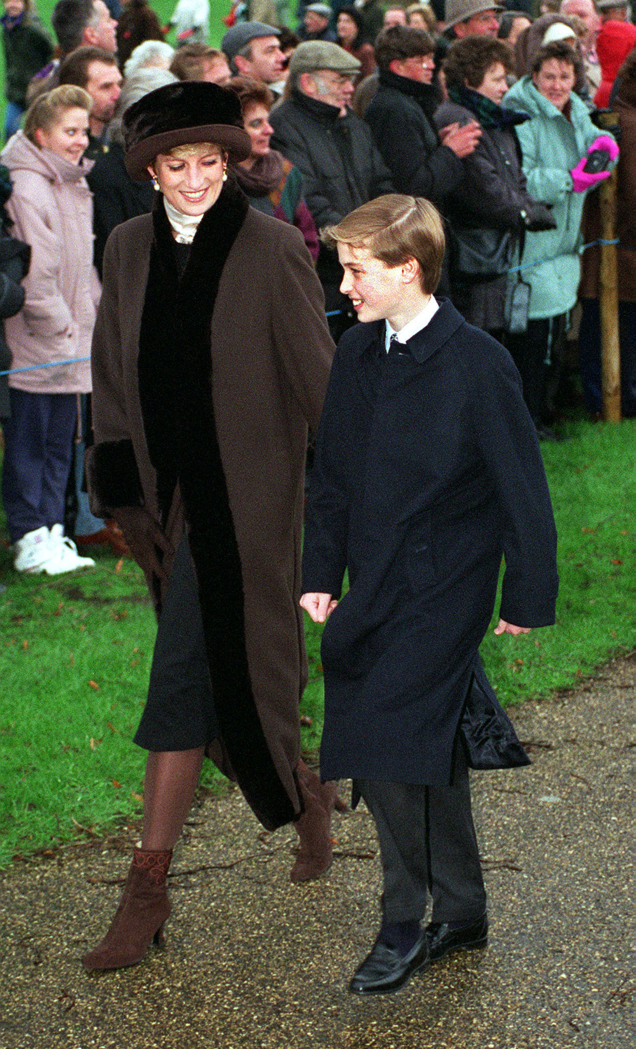 Princess Diana, in a brown coat, and Prince William walking to church on Christmas Day