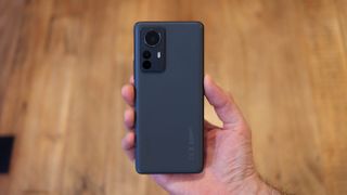 A Xiaomi 12 Pro from the back in someone's hand
