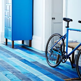 bicycle in room with white walls and wooden flooring