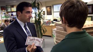 Michael holding a pizza coupon up to the delivery person in The Office