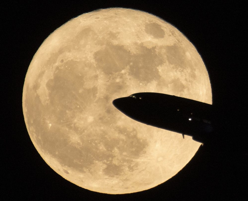 An airplane crosses the supermoon full moon of Dec. 3, 2017 as seen near Ronald Reagon National Airport in Washington, D.C.