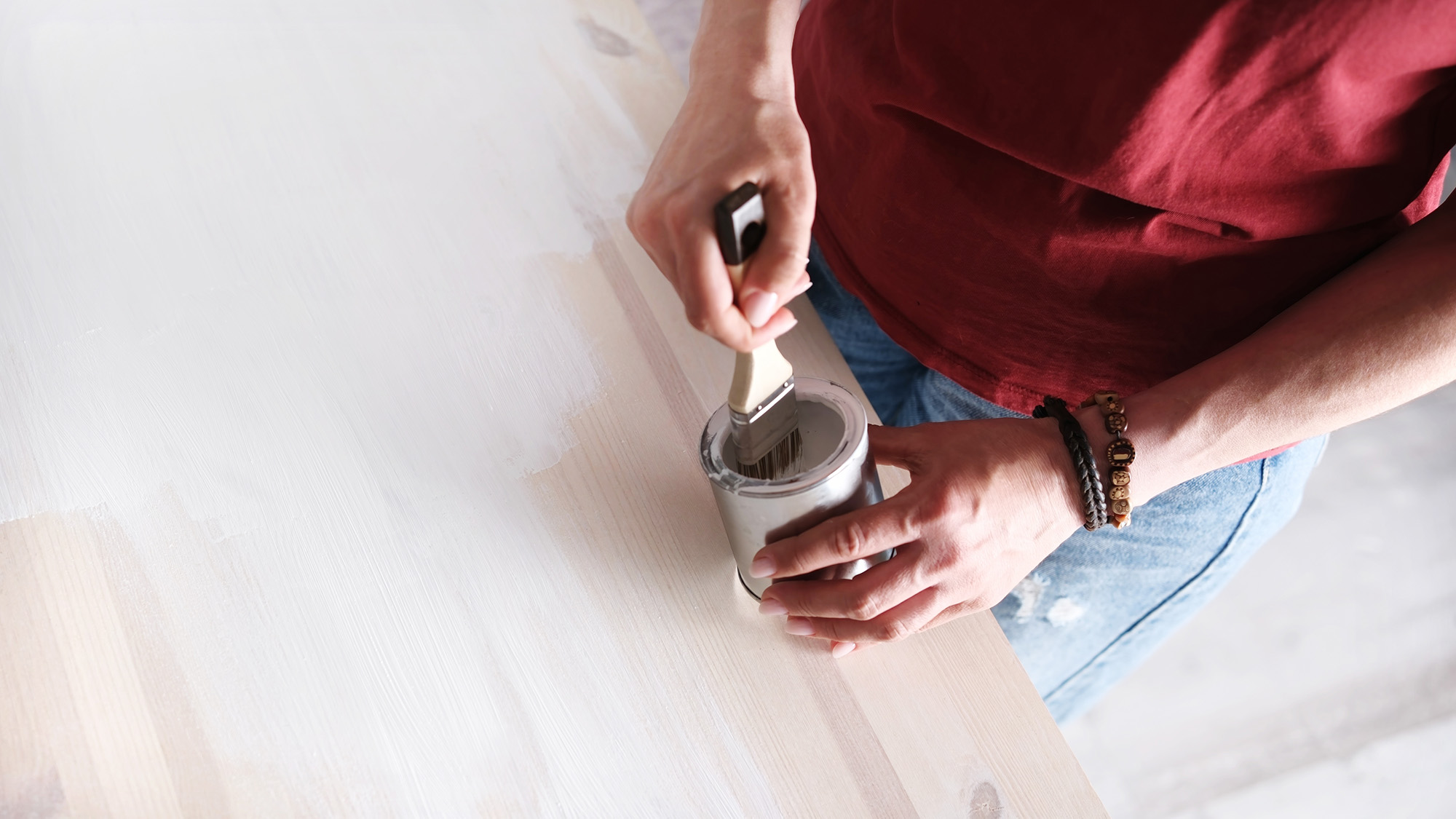 Woman priming furniture surface
