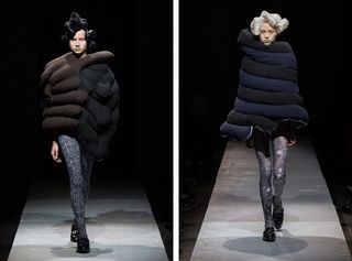 2 female models walking the runway wearing large abstract outerwear