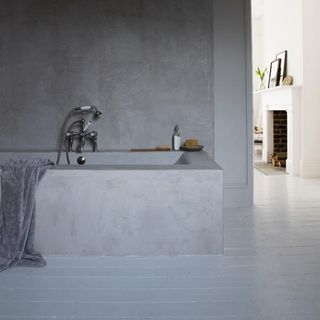 bathroom with grey coloured wall and towel on bath tub