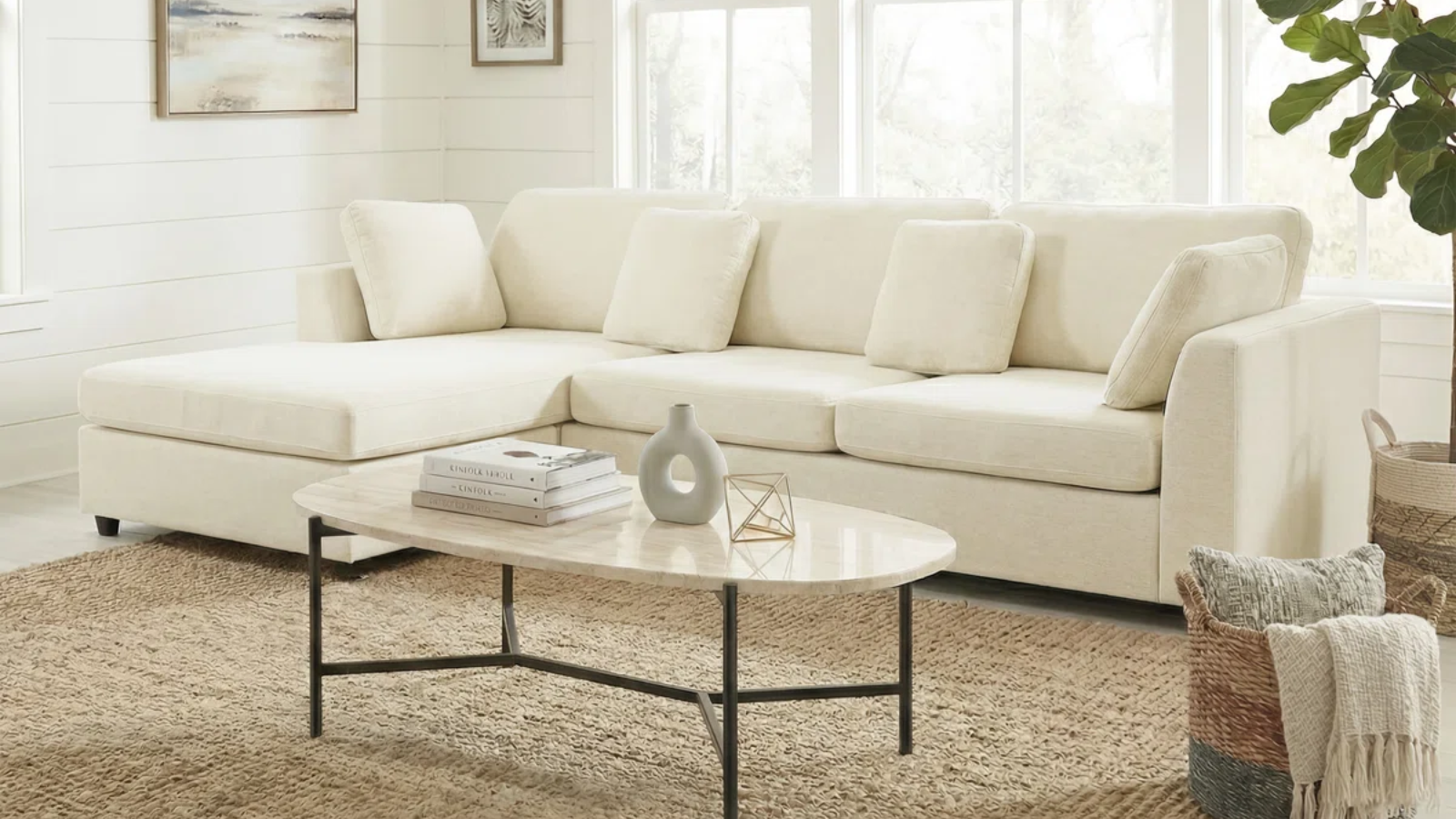 a room with a white sofa, a jute rug, and a marble top coffee table 