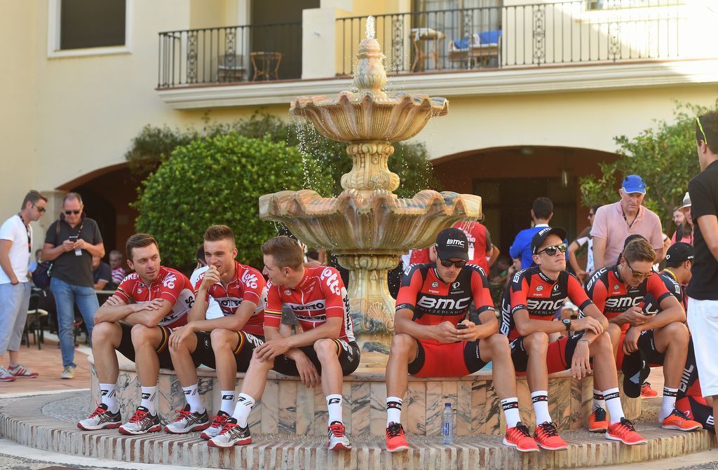 Lotto Soudal and BMC riders check their phones back stage