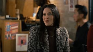 Jackie Tohn as Esther, wearing a black turtleneck under a leopard coat mid-conversation in Nobody Wants This