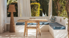 Lola woven floor lamp in an outdoor sitting area with built in seating