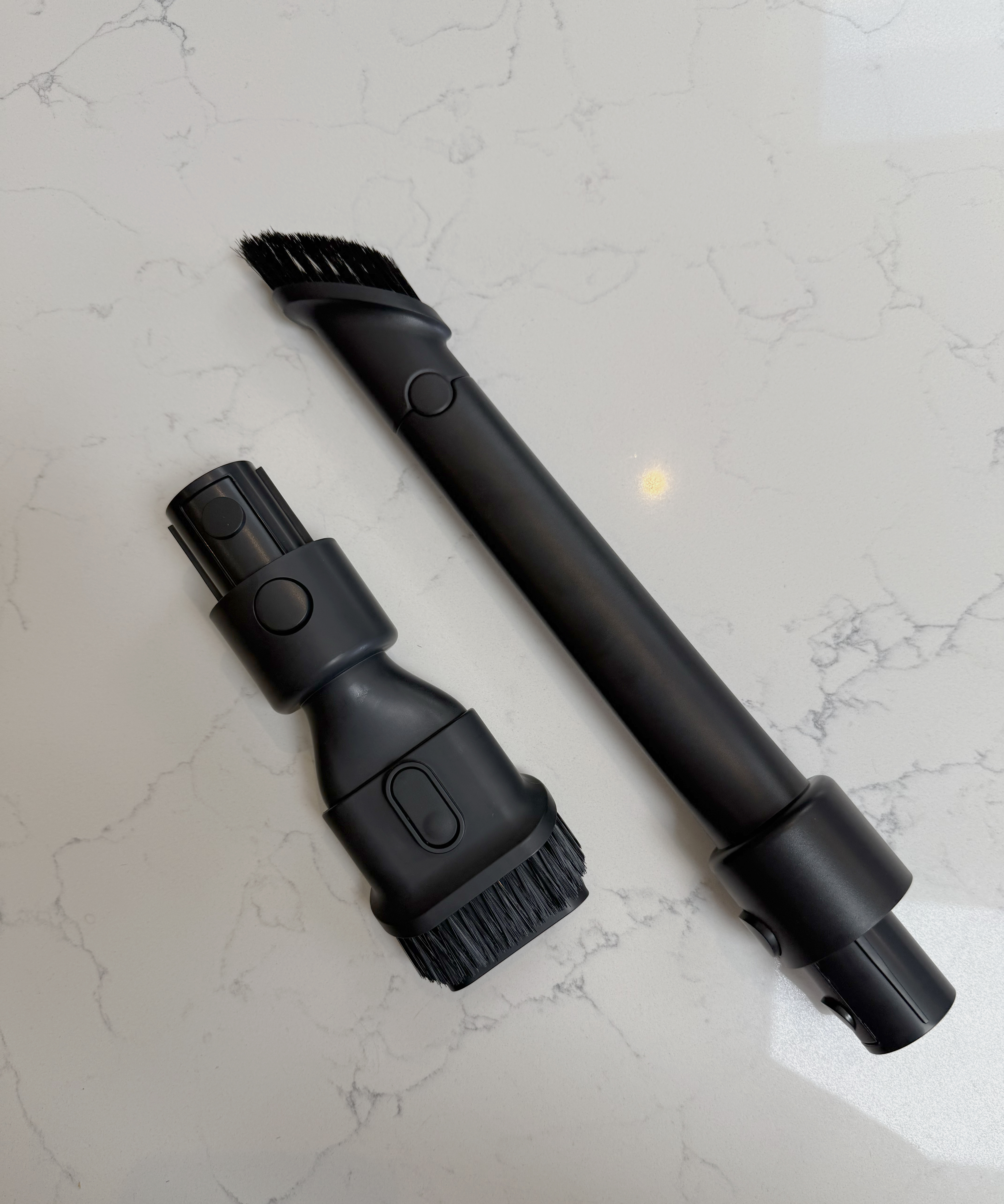 Dreame R10 Pro crevice tool and extension tube placed on a marble-effect countertop