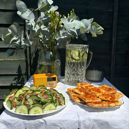 Small table with white table cloth, vase and savory snacks