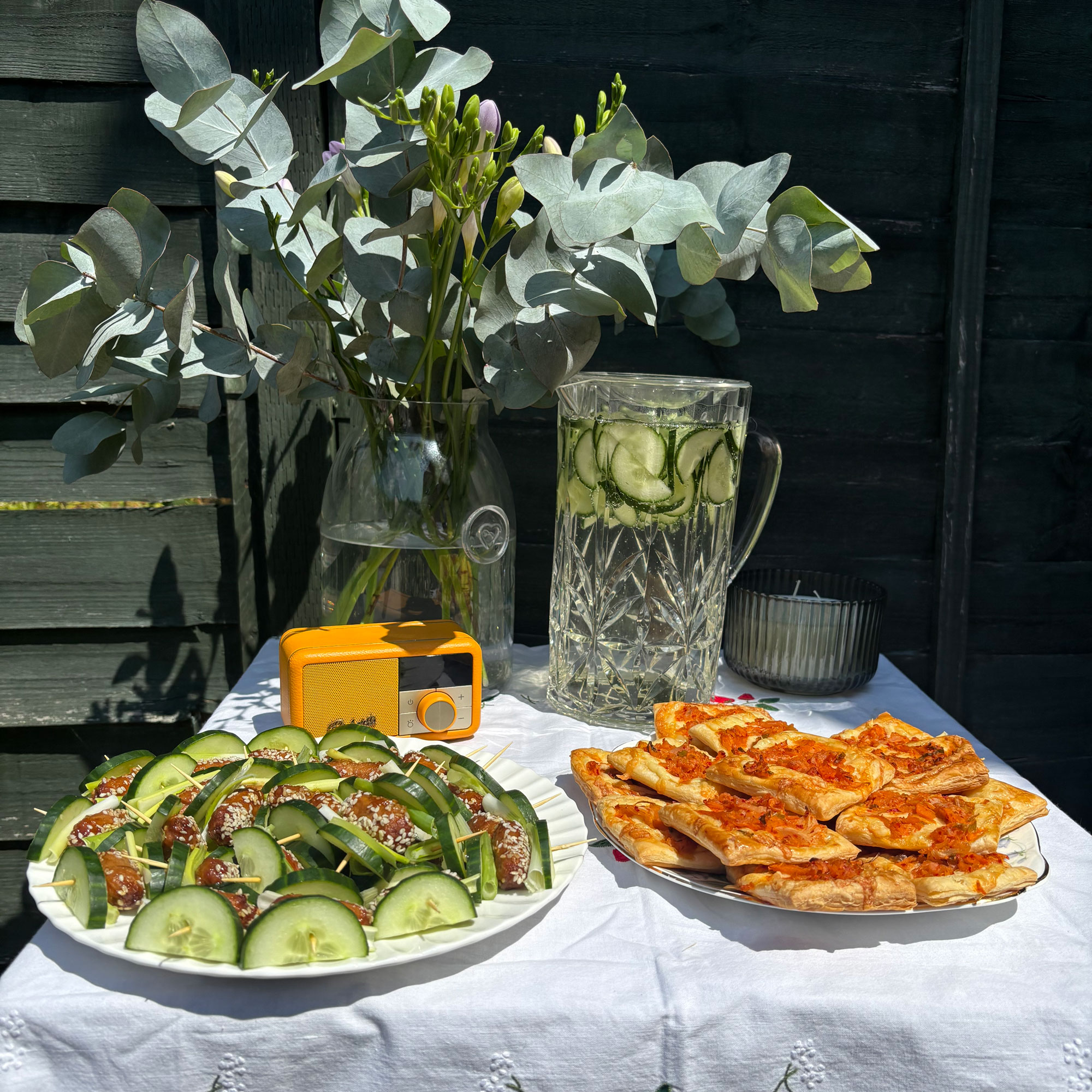 Small table with white table cloth, vase and savory snacks