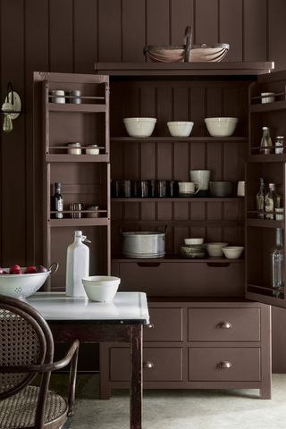 enamel top dining table with chocolate brown cabinetry in kitchen